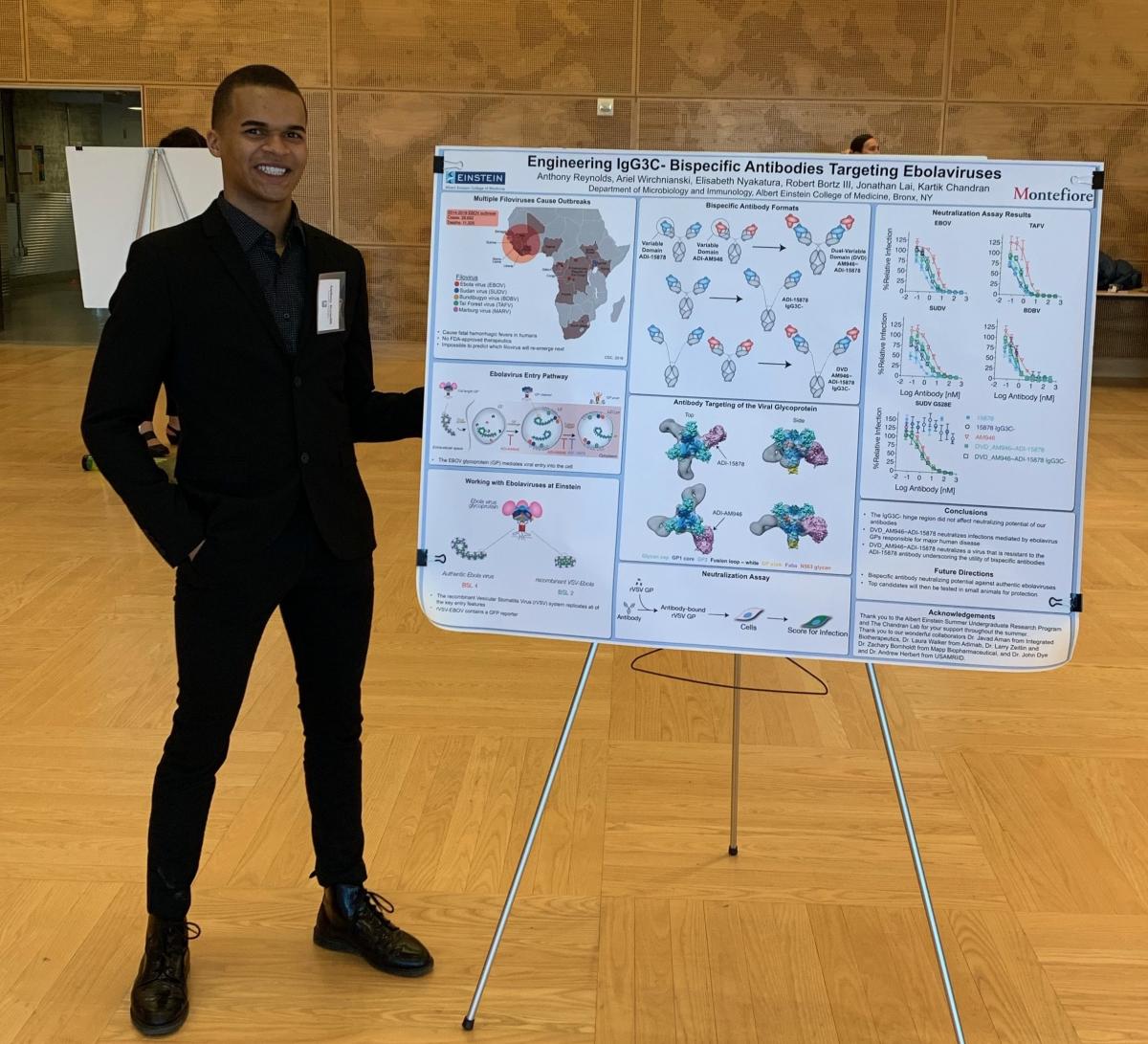 Anthony Reynolds standing next to a research poster.