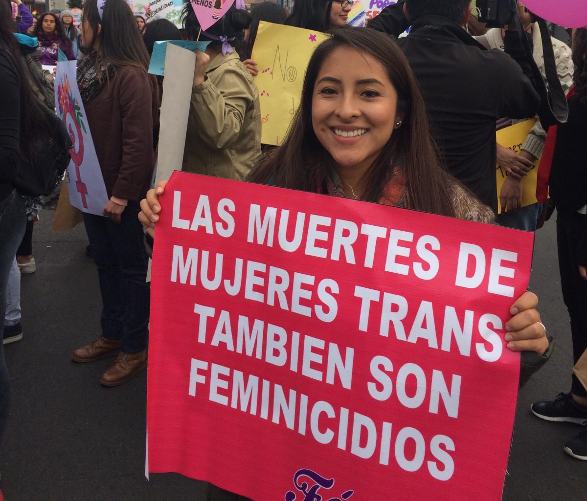 Photo of Katherine holding a sign that says The Deaths Of Trans Women Is Femicide