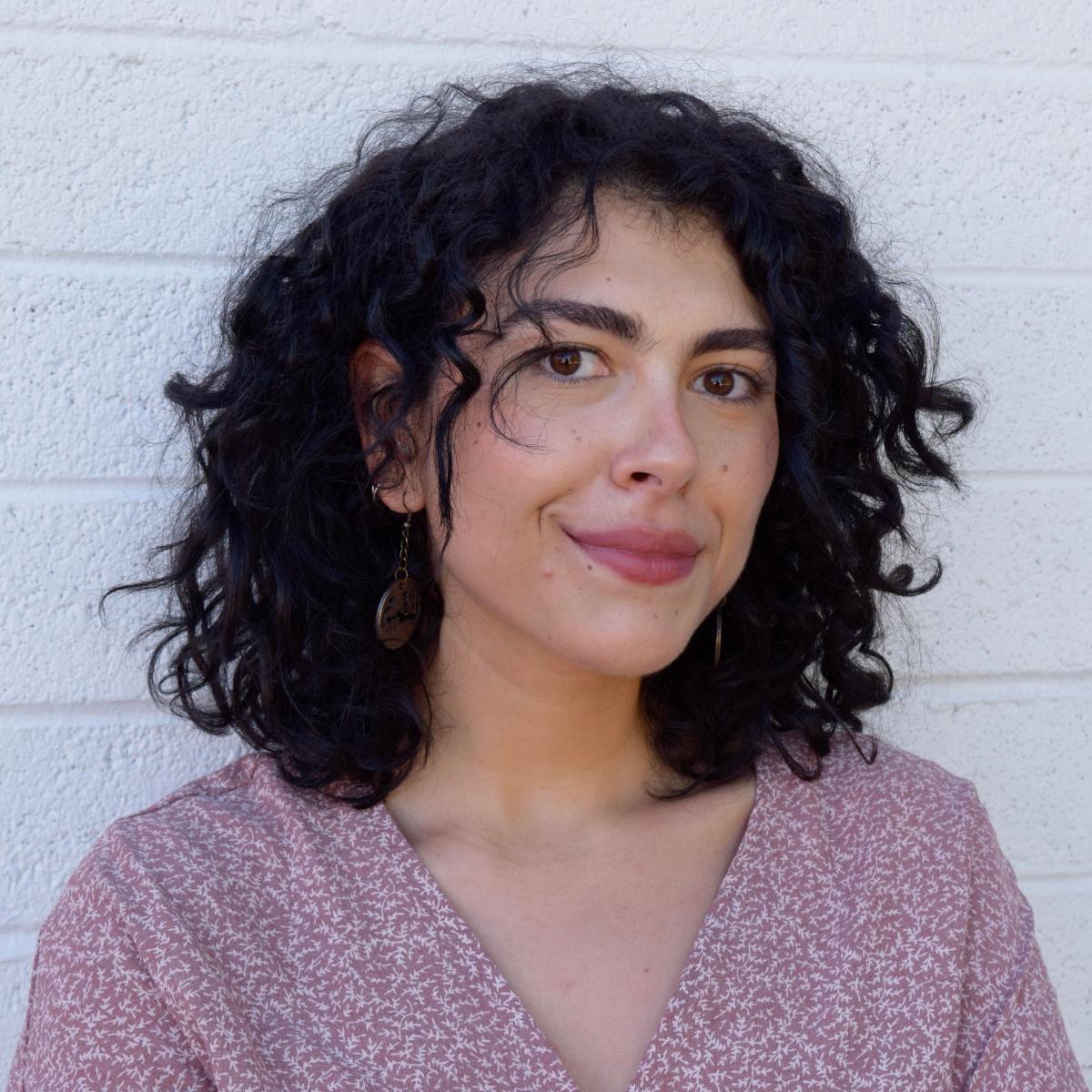 Tasnim standing in front of a white wall.