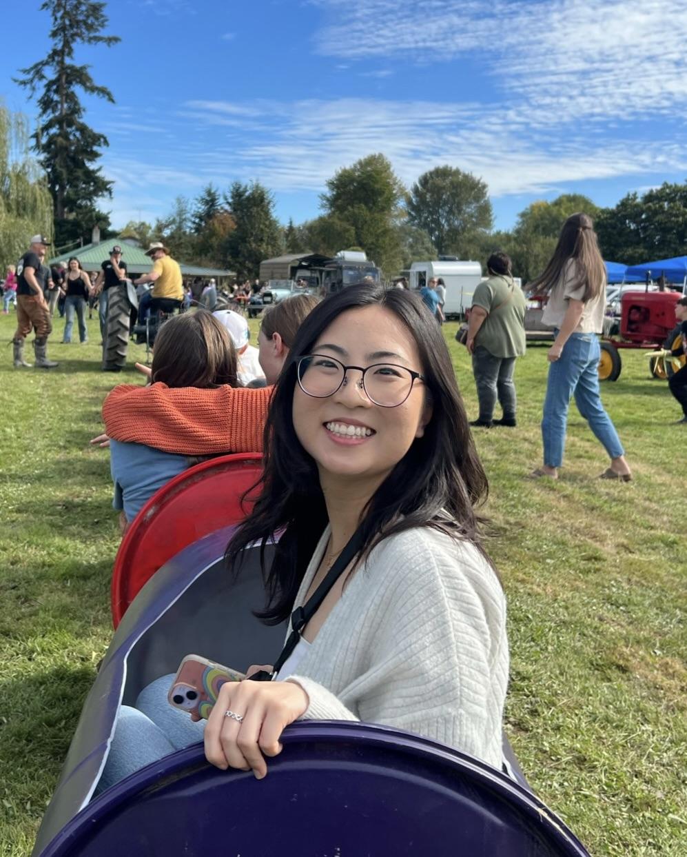 Pathobiology student Yena Park smiles back at the camera while sitting outside in the grass